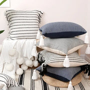 Stack of boho black and white jacquard flower pillow cases with striped tassels for living room decor by decorbites
