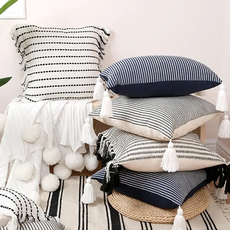 Stack of boho black and white jacquard flower pillow cases with striped tassels for living room decor by decorbites