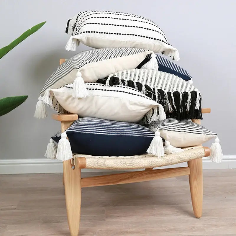 Stack of boho black white jacquard flower pillow case with woven textures tassels for living room decor by decorbites