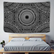 Boho black and white mandala tapestry with intricate swirling patterns hanging as a decorbites indian mandala wall hanging above a wooden bed frame