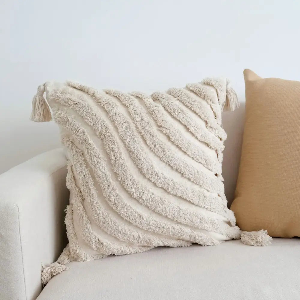Cream-colored tufted tassel cushion cover with woven tassels and plush fabric for boho living room decor