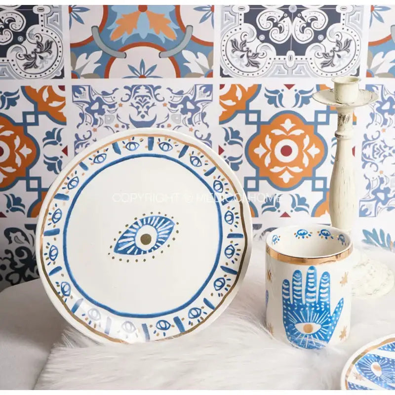 White ceramic eyes ceramic dinner plate with blue and gold bright eyes decorbites motif and decorative borders