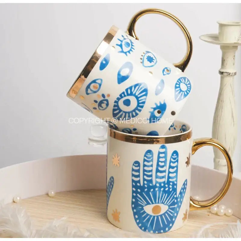 White ceramic mugs with gold rims and blue hamsa hand and eye designs for decorbites bright eyes ceramic dinner use