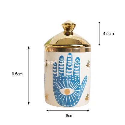 A white ceramic jar with a gold lid and blue hamsa hand design for decorbites bright eyes ceramic dinner use