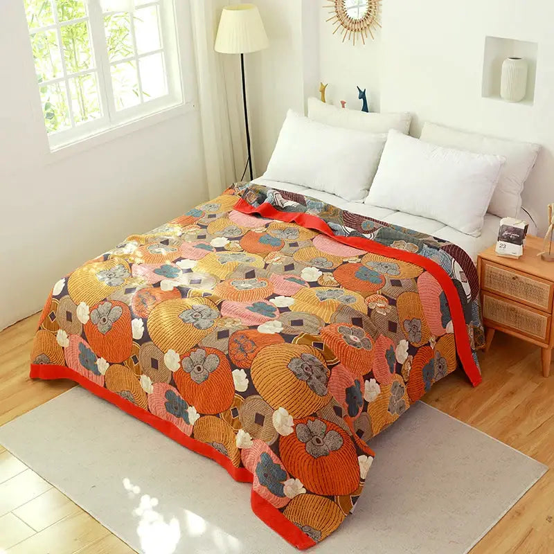 A cozy decorbites boho cotton cover blanket with vibrant persimmon patchwork on a dark sofa chair