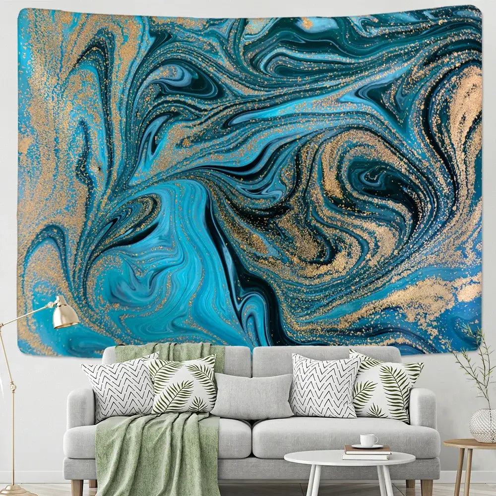A vibrant blue gouache line marbled tapestry with gold swirls hangs above a gray sofa in a boho bedroom setting