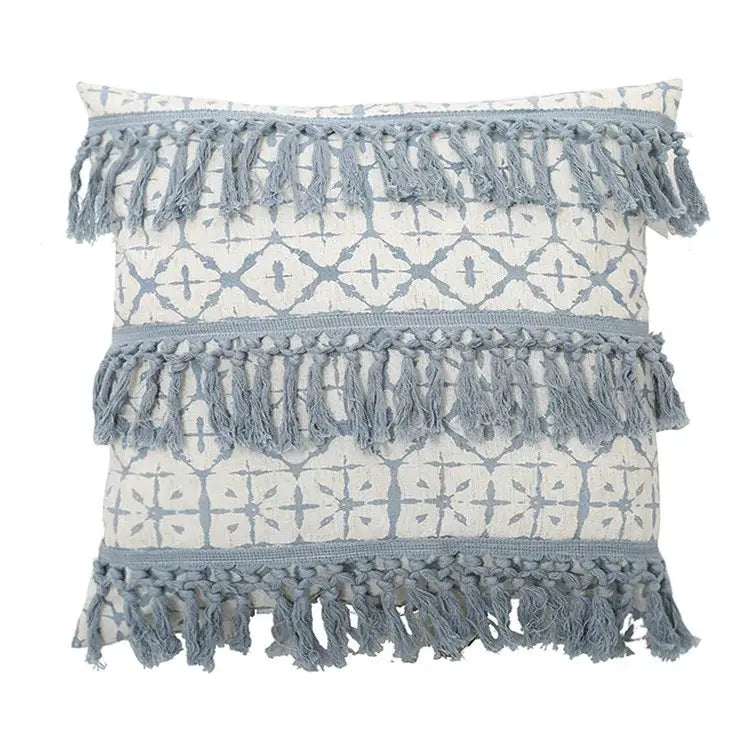 A boho blue and white tassel cushion cover with cream base blue geometric patterns and gray blue fringe decorbites blue tassel