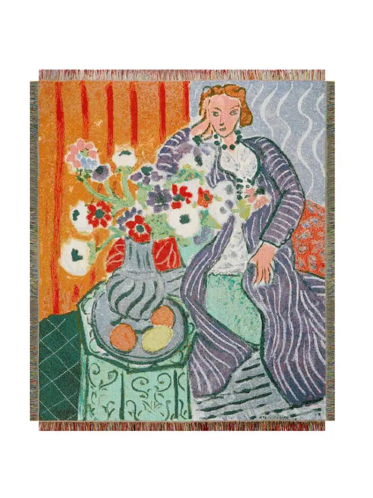 A decorbites boho chic throw blanket with orange and blue leopard print featuring a woven tapestry of a woman in purple and green attire