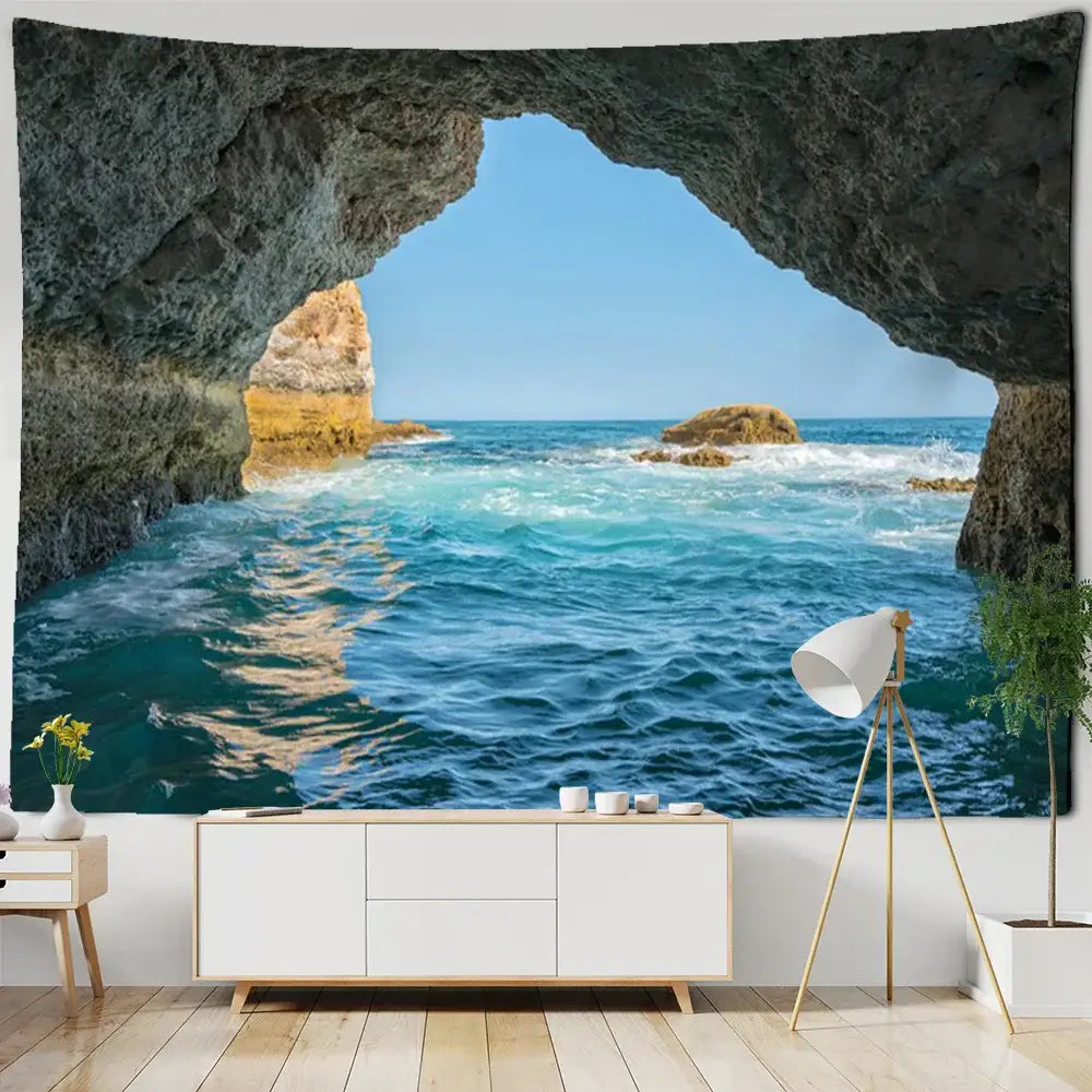 A large boho coastal cave tapestry wall hanging featuring vivid deep blue ocean waves and rocky seaside decor