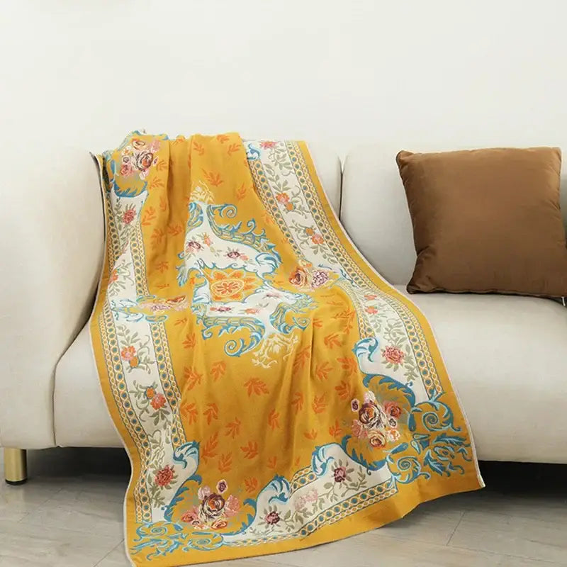 A vibrant yellow decorbites boho cotton gauze bath towel with intricate teal white and soft pink floral paisley patterns