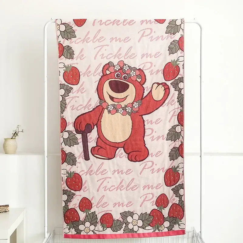 A pink bath towel featuring a red bear with strawberry floral decorbites boho cotton gauze design and tickle me pink text
