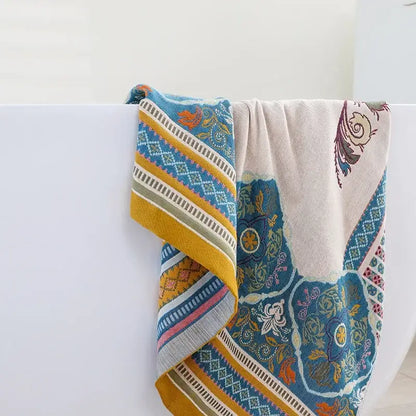 A soft boho cotton gauze bath towel with vibrant blue and yellow floral and geometric patterns for decorbites bathroom wrap