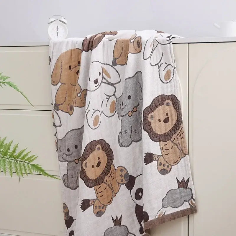 A soft white muslin bath towel with playful cartoon animals in brown and gray from decorbites boho cotton gauze collection