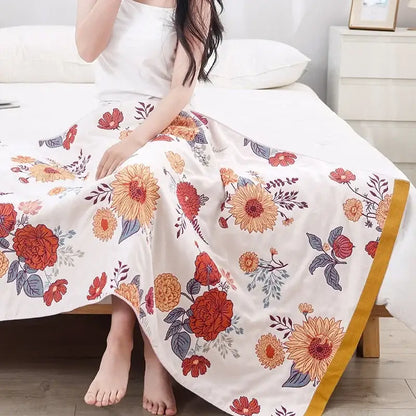 A flowing white maxi skirt with orange and red floral patterns and golden trim in decorbites boho cotton gauze style
