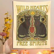 Boho cream and black cat hearts tapestry wall hanging features two black cats with yellow eyes and decorative suns moons flowers in green gold tones decorbites cat hearts