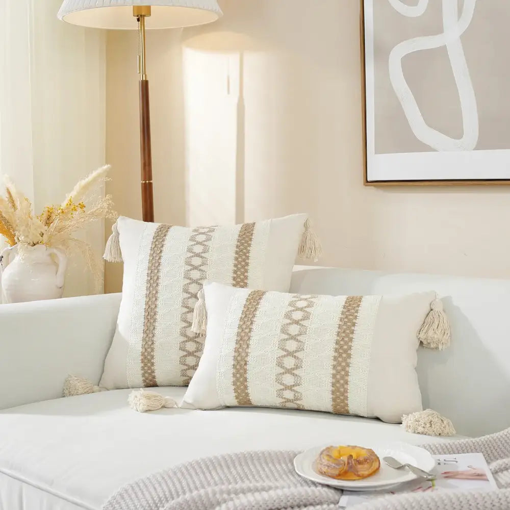 Boho cream and black woven cushion cover with beige geometric stripes and tasseled throw pillows for living room use