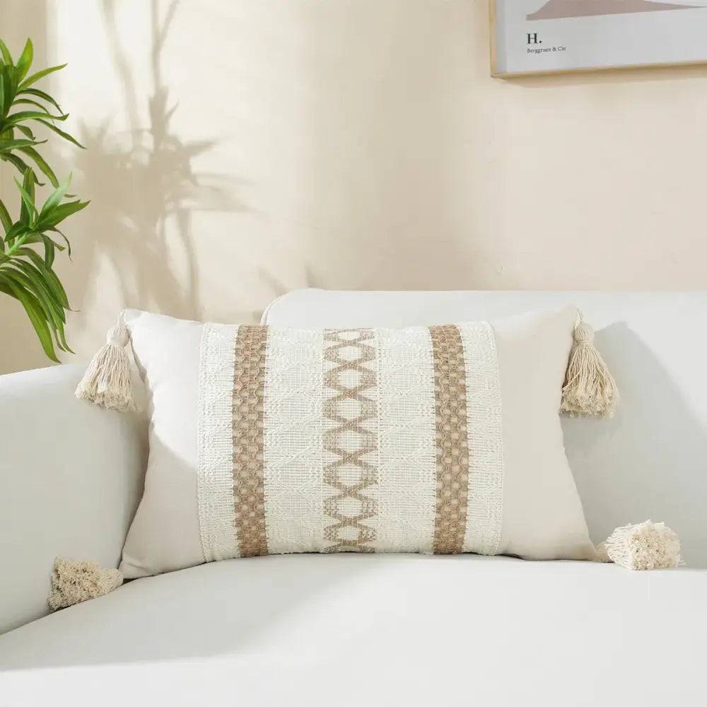 Beige woven cushion cover with black geometric stripes and matching tassels for boho living room decor