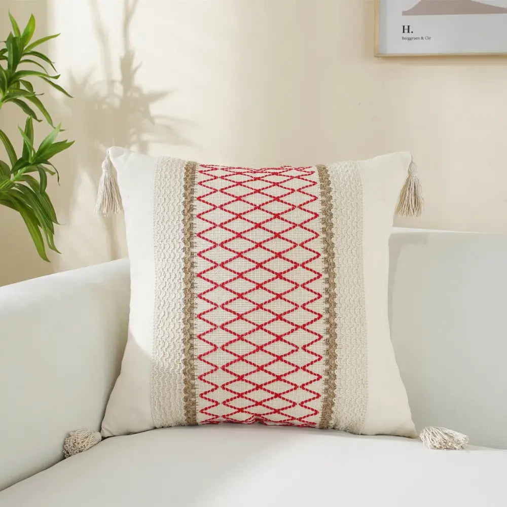 Boho cream woven cushion cover with red diamond embroidery, beige stripes, and tasseled corners for living room use