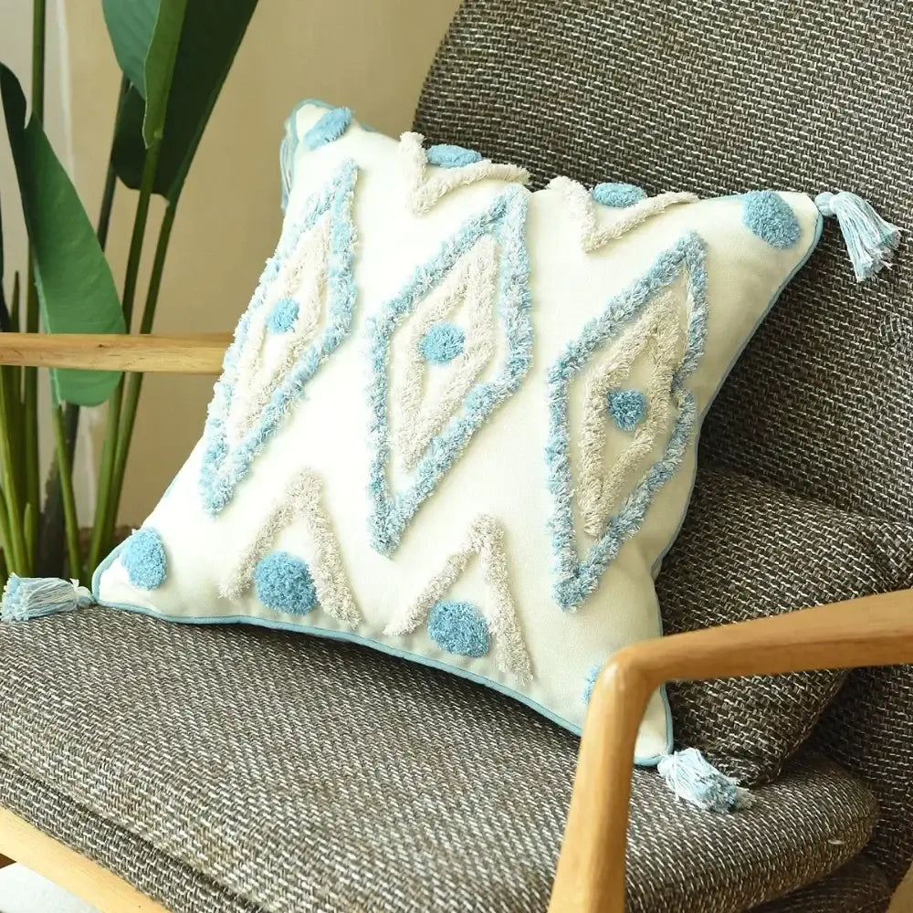 Cream-colored cushion cover with light blue and beige geometric embroidery fluffy pom-poms and tassels decorbites boho blue diamond