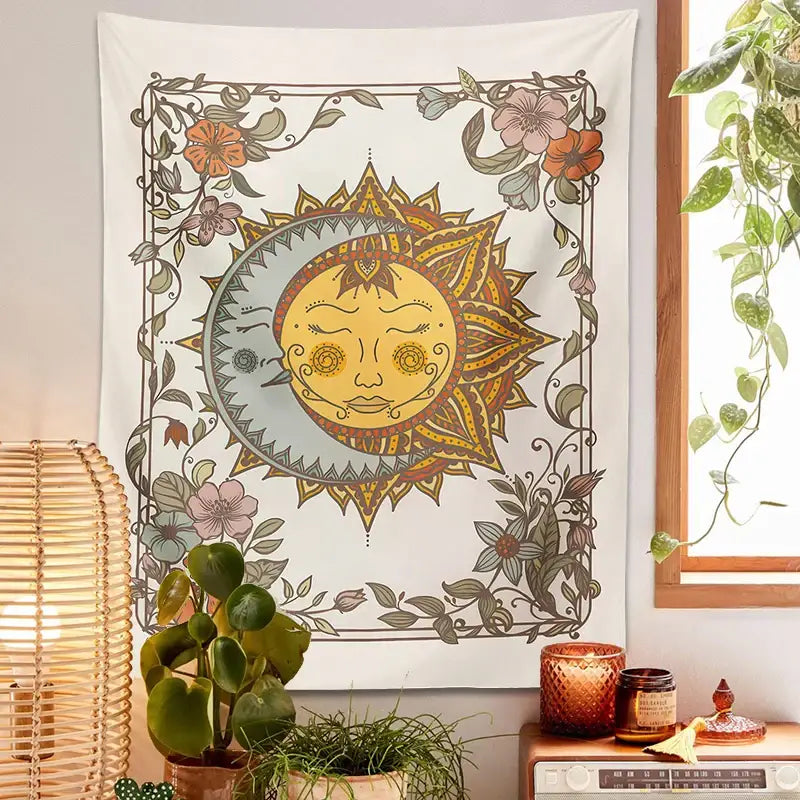 A cream-colored boho tapestry with a detailed celestial sun and floral vines in muted orange pink and green hues decorbites celestial sun