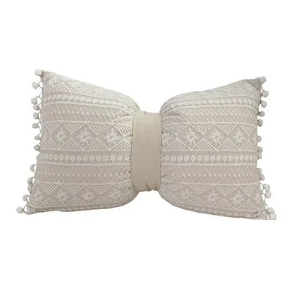 Beige bow-shaped cushion cover with intricate lace floral pattern and pom-pom trim decorbites boho white style