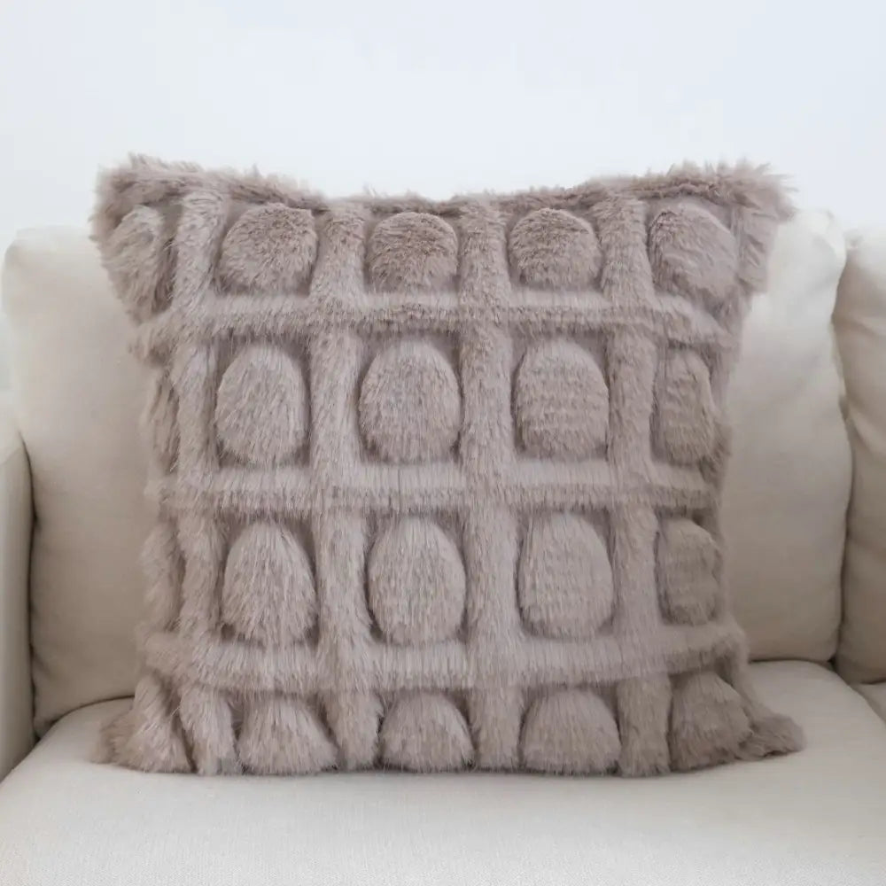 A plush taupe cushion cover with embossed grid of raised circles featuring decorbites boho leaf geometry tufted design