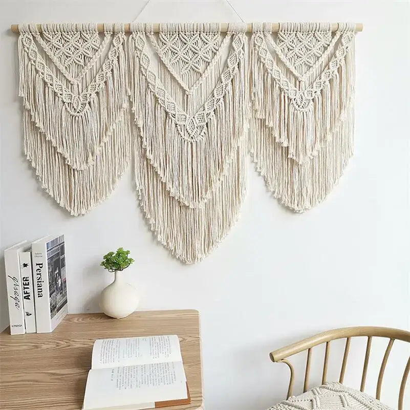 Cream-colored macrame wall hanging tapestry with intricate geometric patterns and long fringe for boho bedroom decor