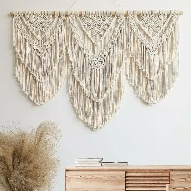 Cream-colored macrame wall hanging tapestry with intricate geometric patterns and long fringe for bedroom decor