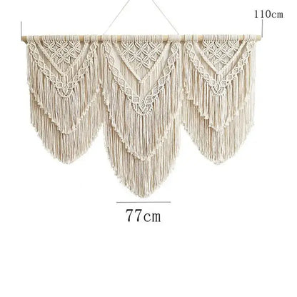 Beige macrame wall hanging tapestry with intricate geometric patterns and long fringe suspended from wooden rod