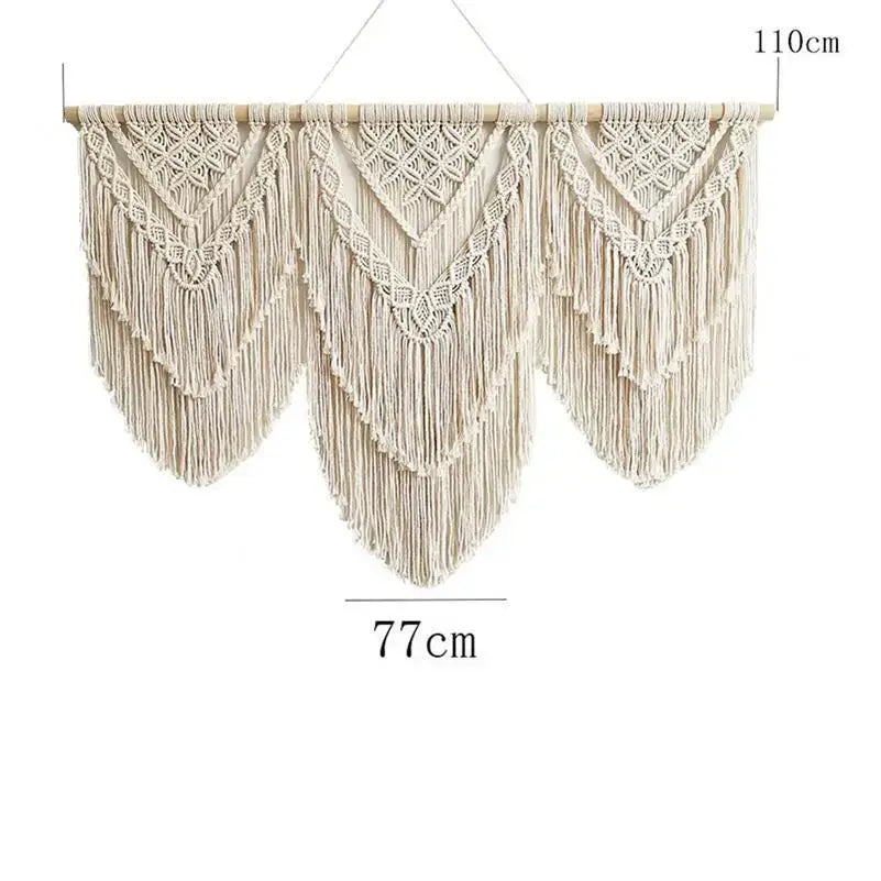 Beige macrame wall hanging tapestry with intricate geometric patterns and long fringe suspended from wooden rod