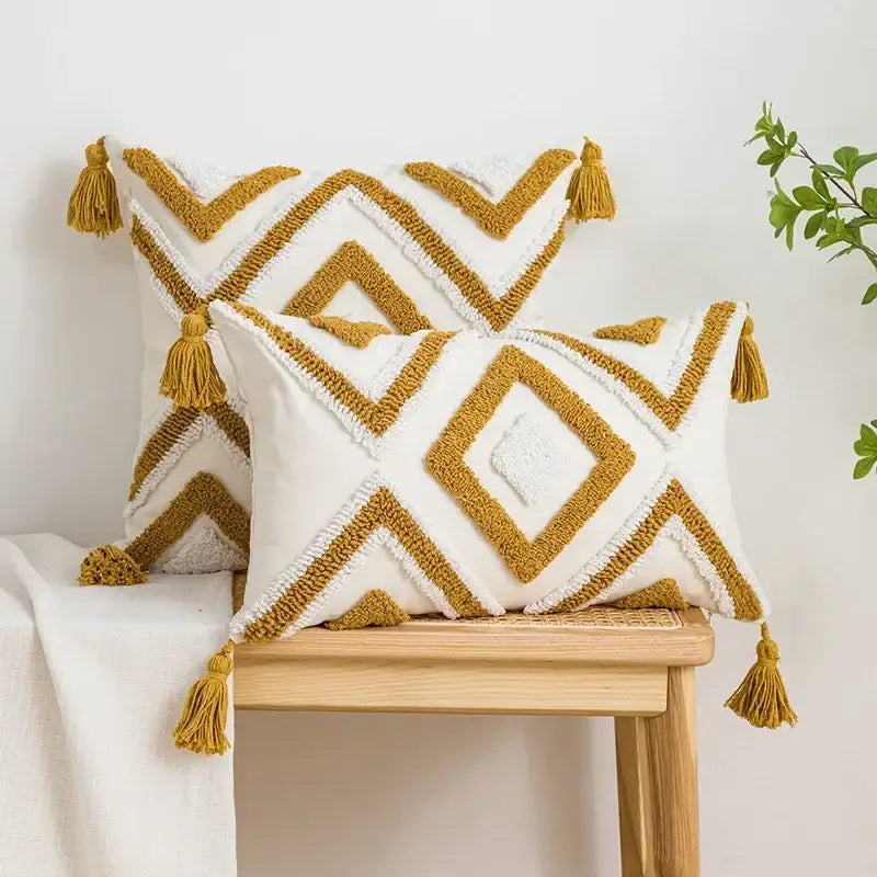 Boho cream and tan geometric tufted fringe cushion cover with white and mustard-yellow pillow case and tassel accents