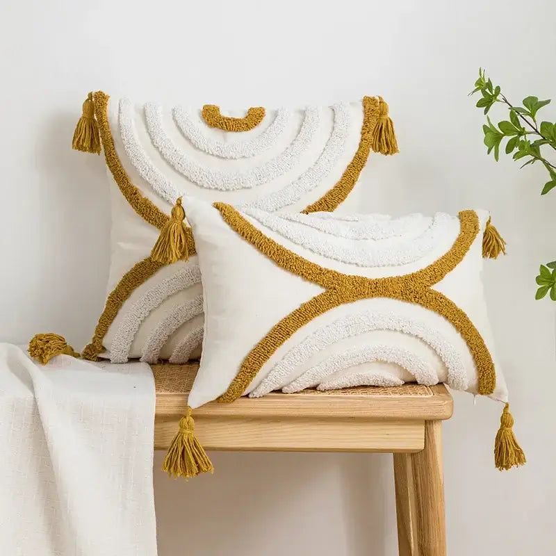 White and mustard-yellow boho cushion cover with geometric tufted fringe and tassel accents for living room use