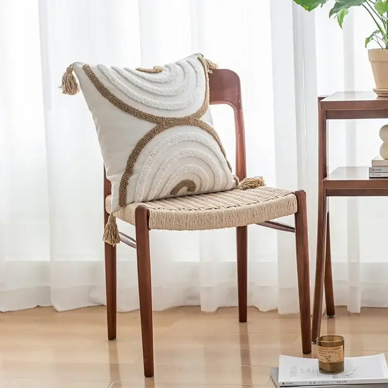 Boho cream and tan cushion cover with tufted fringe, textured woven concentric circles, and decorative tassels
