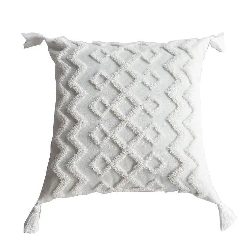 Boho cream textured pillow cover set featuring a white square pillow with diamond pattern and tassels at each corner