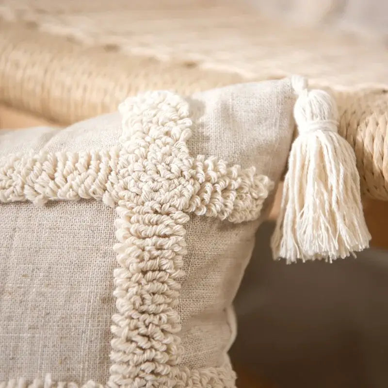 Beige linen pillow cover set with textured cream woven cross and tassel accents for boho bedroom decor