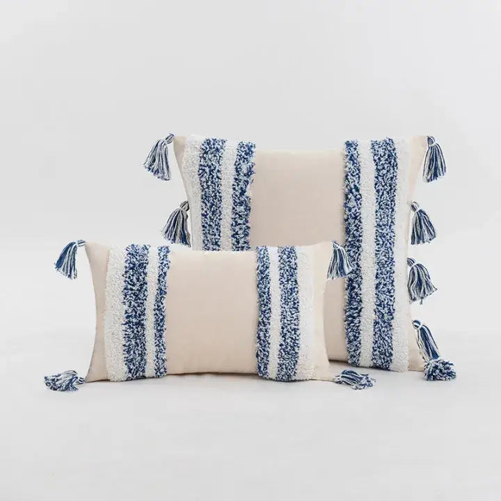 Cream-colored boho tufted cushion cover with textured navy white stripes and tassels for living room decor