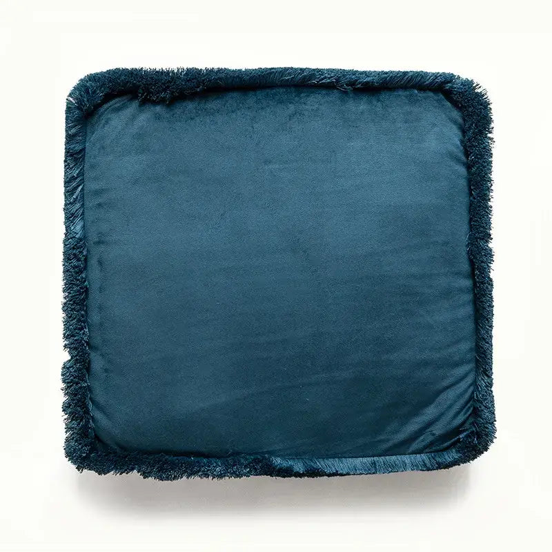 Deep teal velvet cushion with a fringed edge.