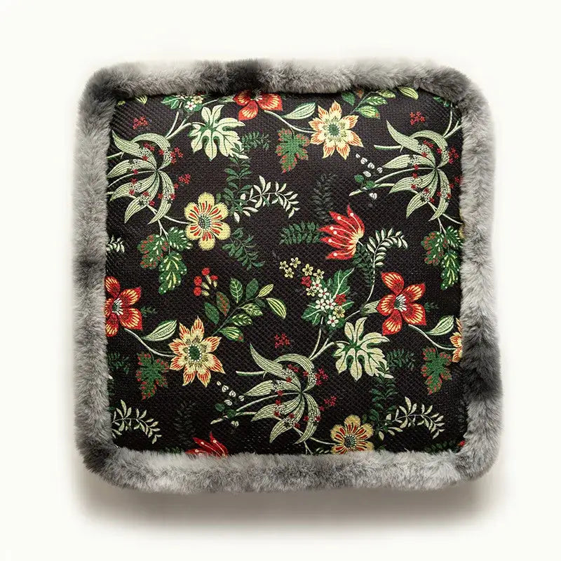 Black floral-patterned cushion with gray faux fur trim.