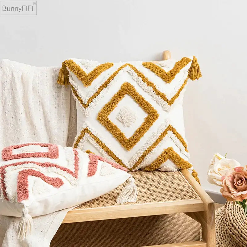 Cream-colored boho diamond pillow with mustard-yellow geometric patterns and tassels in textured cushion covers by decorbites