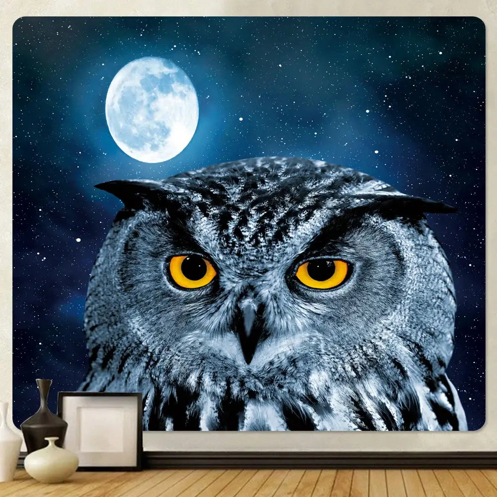 A gray and black owl with yellow eyes on a starry night tapestry with full moon in decorbites boho elephant mandala wall art