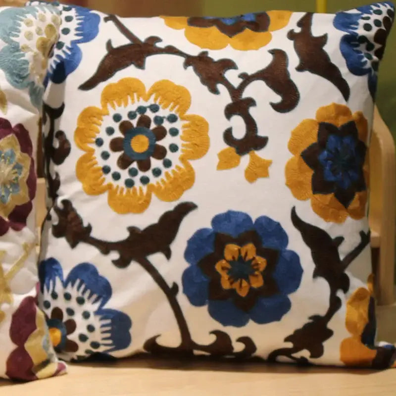 A square flower elephant pillowcase with a white base and vibrant yellow blue and brown embroidered decorbites ethnic flower patterns