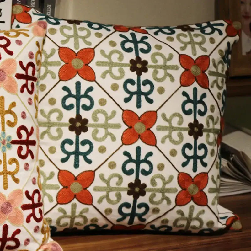 A square flower elephant pillowcase with white base and embroidered orange teal olive green and brown floral patterns