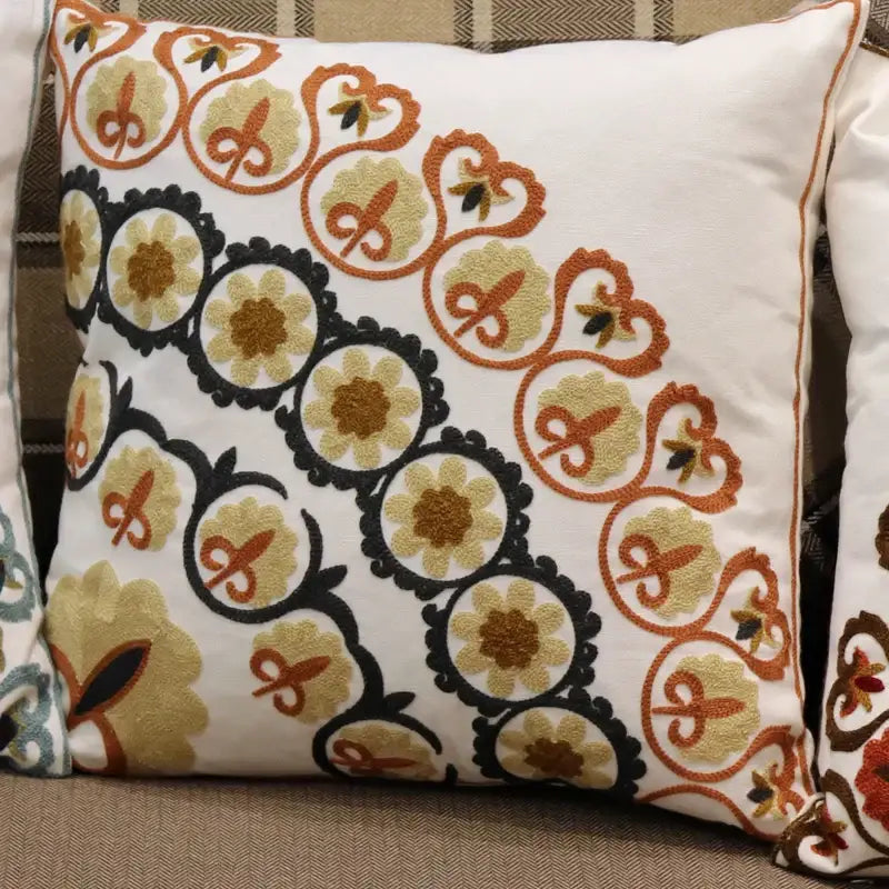 White throw pillow with intricate ethnic flower elephant embroidery in black orange and gold thread for boho decorbites decor