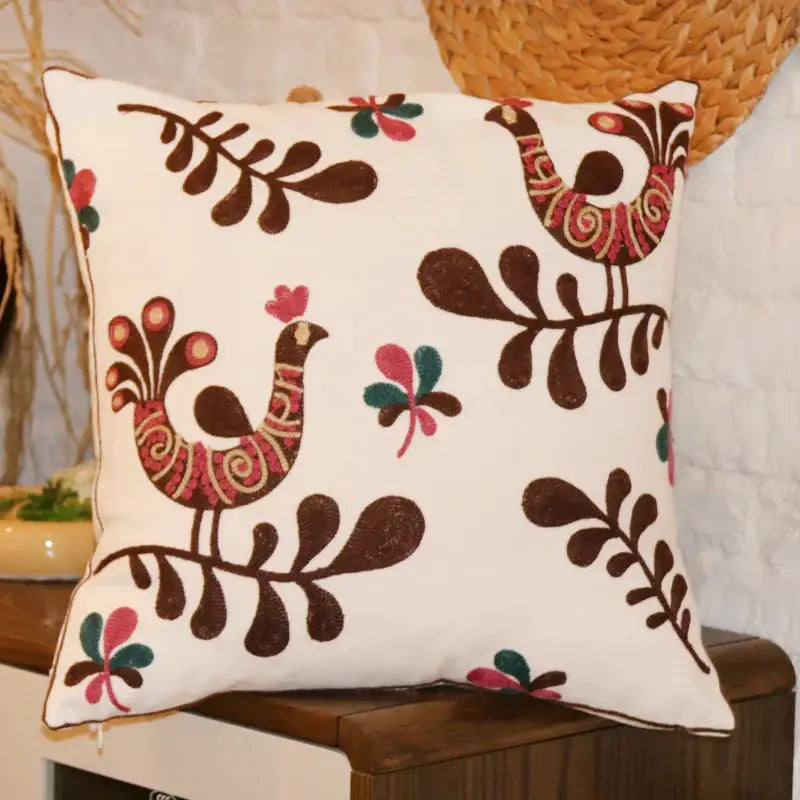 White cushion with embroidered brown birds red gold detailing and pink green floral motifs for decorbites ethnic flower decor