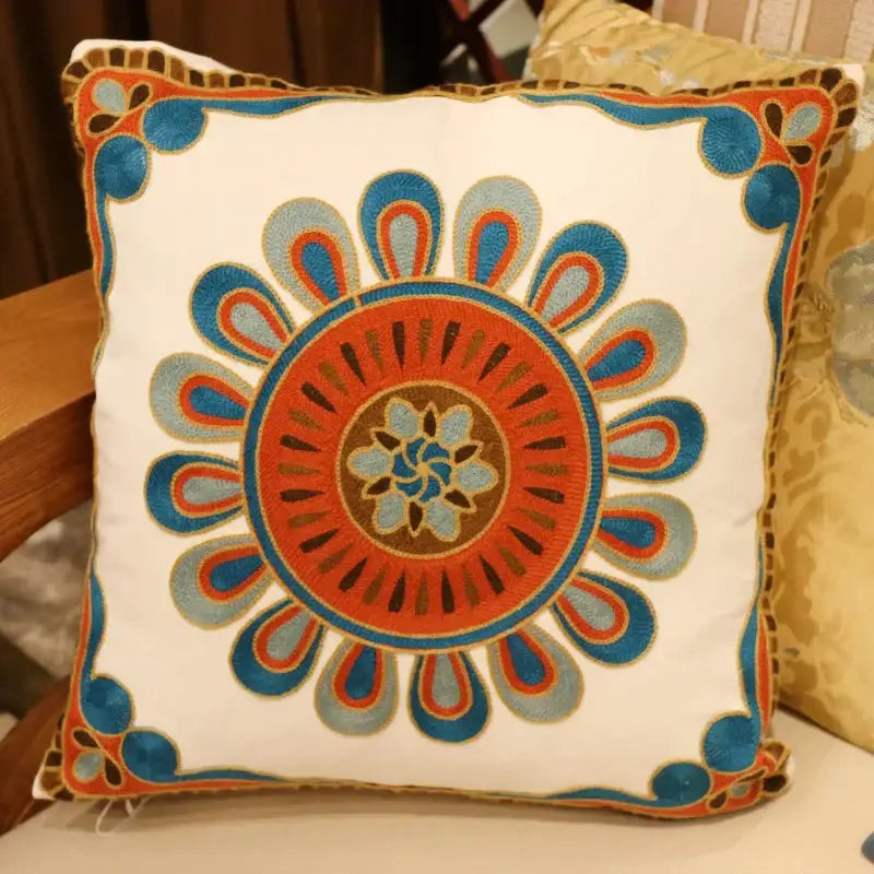 A white square flower elephant pillowcase with embroidered orange blue and brown floral patterns and decorative border