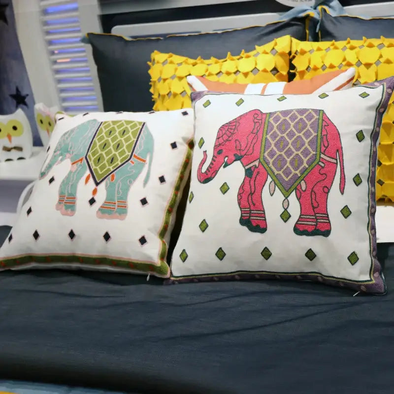 Two embroidered ethnic flower elephant throw pillows in teal green and vibrant pink for boho decorbites bedroom decor