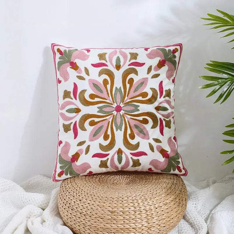 A square pillow cover with intricate pink gold and green floral embroidery on cream decorbites boho farmhouse style