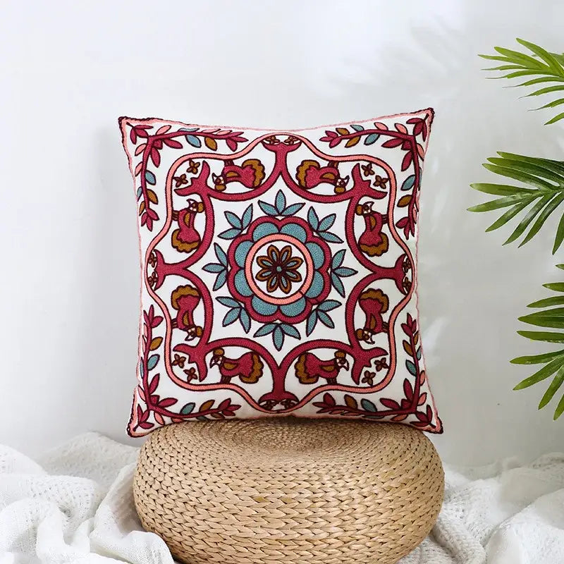 A square cream embroidered pillow cover with vibrant red teal pink and brown floral pattern for boho farmhouse decorbites