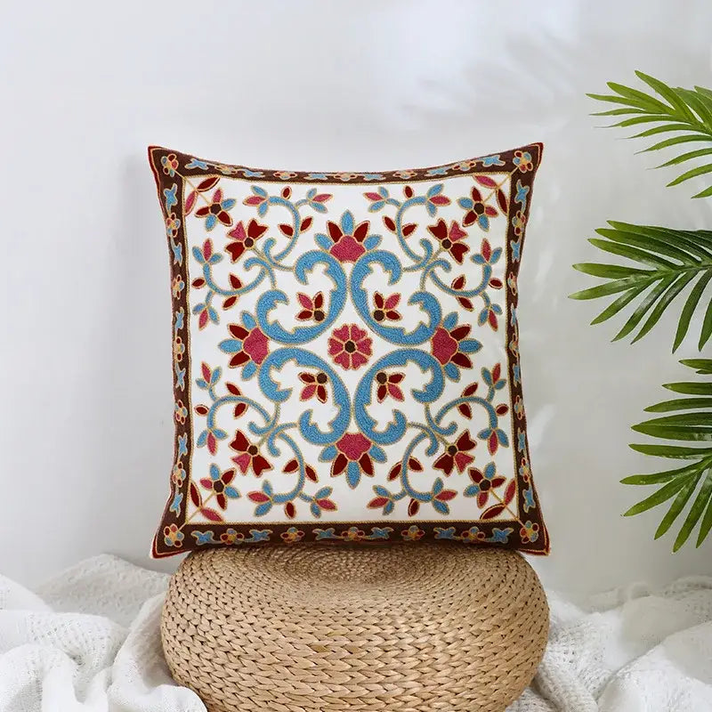 White cushion pillow cover with intricate blue and red floral embroidery on brown border decorbites boho farmhouse floral design