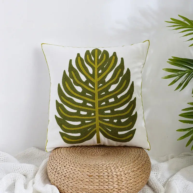 White boho farmhouse floral pillow covers with embroidered green monstera leaf and yellow green border by decorbites